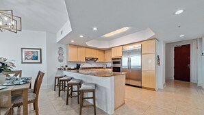 Una cocina moderna con una isla central, armarios de madera y electrodomésticos de acero inoxidable.