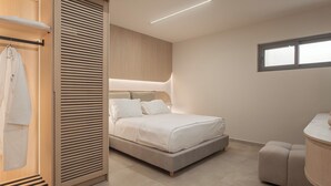 Un dormitori modern amb un llit, un armari i un espai per maquillar-se.