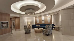 A spacious lobby with a modern chandelier, a blue sofa, and patterned armchairs. - The Royal Bloom Room-1409TowerA (Pasay)
