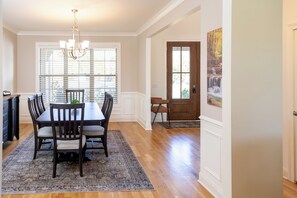 A dining area with a wooden table, chairs, and a chandelier. - Nashville Oasis 4 Bed 3 Bath Home 30 MINUTES TO DOWNTOWN - 35 Nashville Airport (Pleasant View)