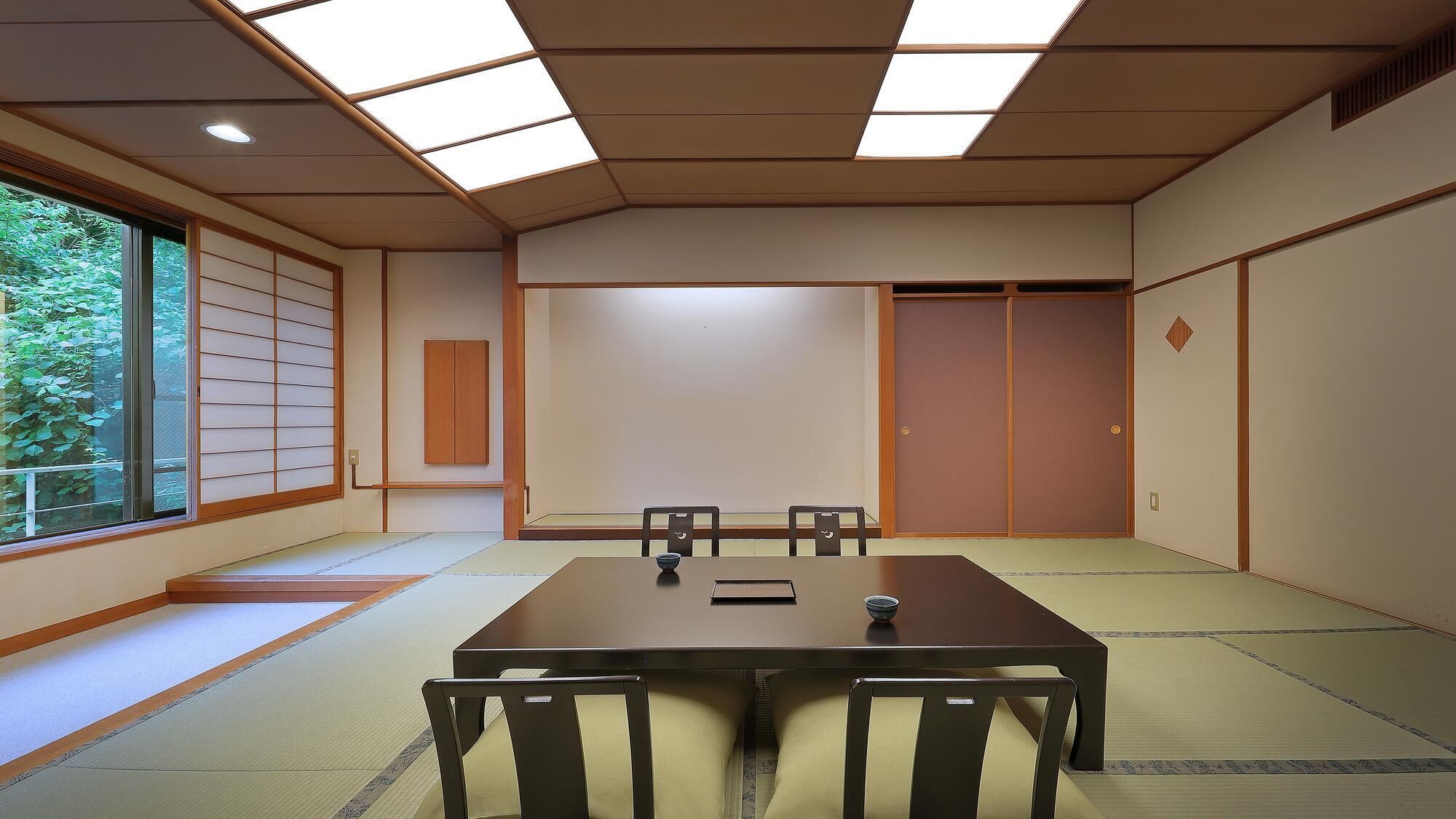A traditional Japanese room with tatami flooring, a low table, and sliding doors.