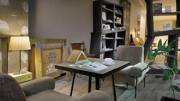 Un rincón acogedor para leer con una mesa, sillas y una estantería.