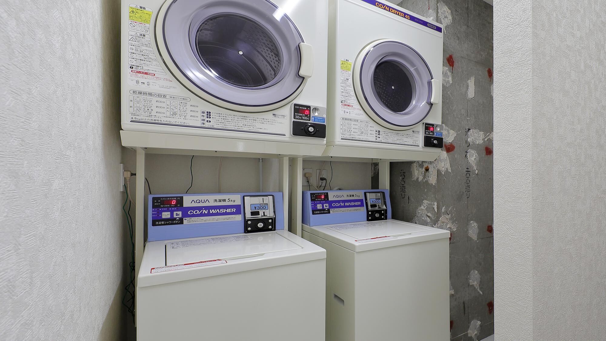 A laundry facility with two front-loading washing machines and two dryers.