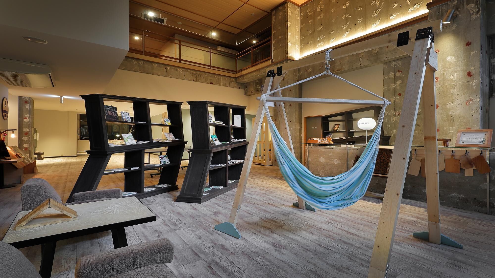 A modern interior with a hammock, wooden shelves, and a dining area.