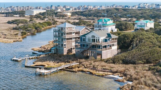A multi-story waterfront property with balconies, a dock, and a view of the sea. - Sounds Good - Sound front home with stunning views and hot tub (Buxton)