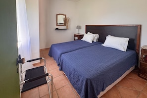 A hotel room with two beds, a nightstand, a lamp, and a chair. - A peaceful Fuseta escape with terrace, garden, and private parking. (Fuseta)