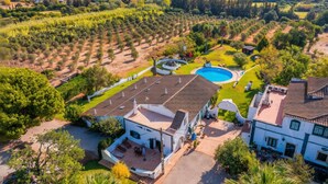 A residential area with a swimming pool, white houses, and surrounding greenery. - A peaceful Fuseta escape with terrace, garden, and private parking. (Fuseta)