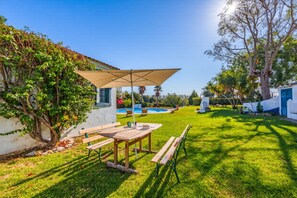 A patio with a table and benches, a pool, and a tree. - A peaceful Fuseta escape with terrace, garden, and private parking. (Fuseta)