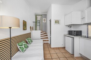 A compact kitchen with a microwave, a small refrigerator, and a staircase leading to another room. - A peaceful Fuseta escape with terrace, garden, and private parking. (Fuseta)