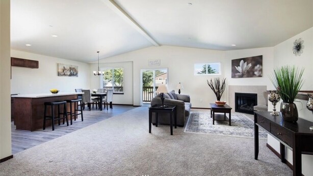 A spacious living area with a kitchen, dining area, and a fireplace. - Serene 3-bedroom house perfect for relaxing stays in SeaTac, Burien, Seattle (SeaTac)
