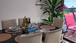 A dining area with a table set for four, chairs, a potted plant, and artwork on the wall. - APARTMENT IN SANTA MARTA EL RODADERO LAURELES BUILDING 801 With ocean view (Gaira)