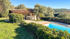 Une villa avec piscine, entourée d’une végétation luxuriante et d’oliviers.