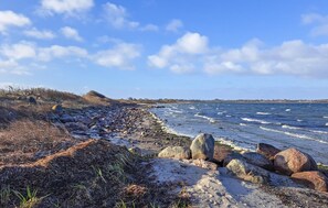 A rocky shoreline with waves, clear sky, and distant land. - Amazing home in Humble with WiFi (Humble)