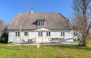 A house with a tiled roof, a small balcony, and a patio with outdoor furniture. - Amazing home in Humble with WiFi (Humble)