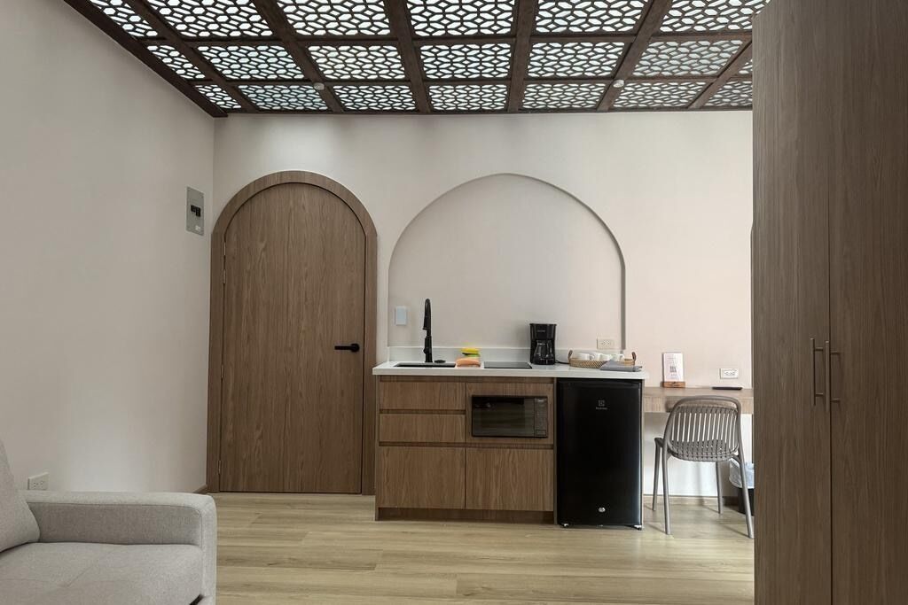 A compact kitchen with a microwave, coffee maker, and a small refrigerator.