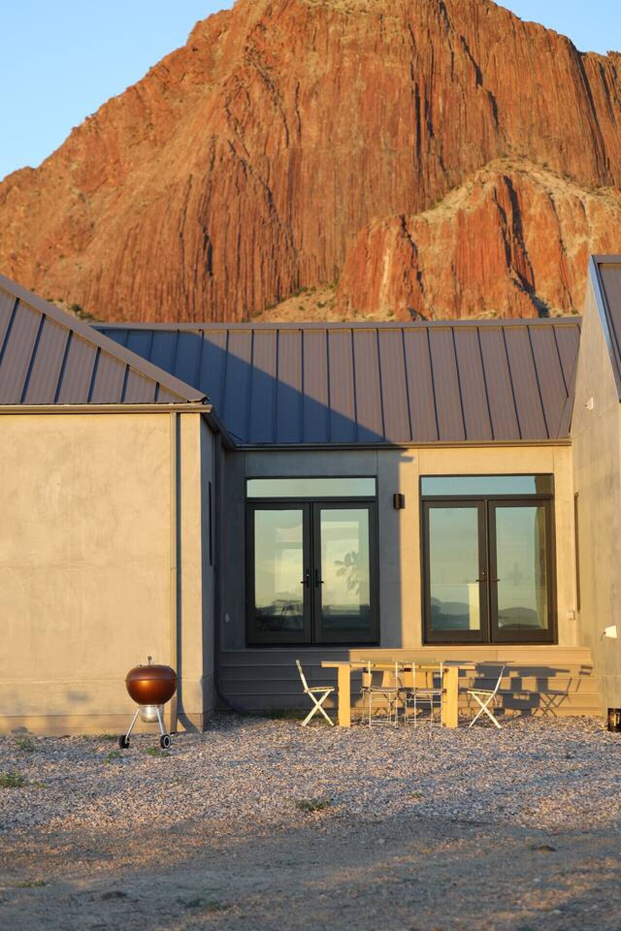 Un bâtiment moderne doté d’une grande fenêtre et d’un barbecue à l’extérieur.