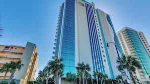 A tall hotel with a modern design, featuring a prominent logo at the top. - Experience the Ultimate Beachfront Lifestyle at Ocean's One (Myrtle Beach)