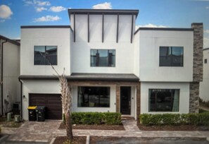 A modern two-story house with a garage, large windows, and a stone accent wall. - Spacious 5-bedroom house in beautiful Loughman with AC and gym (Loughman)