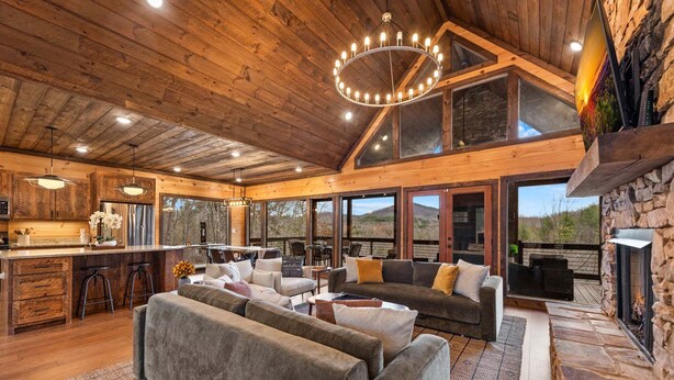A spacious living area with a fireplace, wooden ceiling, and large windows. - 249 Ranger Station - Mountain View | Pet Friendly | Hot Tub | Shuffleboard | Cornhole (Morganton)