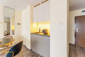 A compact kitchen with a sink, countertop, and cabinets. - Royal Tulip Sand Seaside Studio (Kołobrzeg)