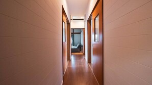 A modern hotel hallway with wooden flooring and light-colored walls. - Luxe 6-bedroom Ski Lodge Myoko Kogen (Myoko)