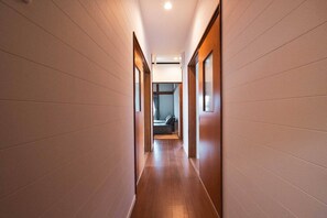 Un pasillo moderno de hotel con suelo de madera y paredes de color claro.