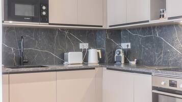 A modern kitchen with a Bosch microwave, a toaster, a kettle, and a coffee maker on the counter.
