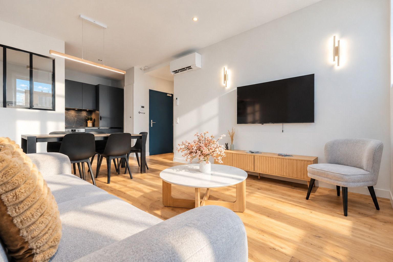 Un salon moderne avec un canapé, une table basse et un téléviseur fixé au mur.