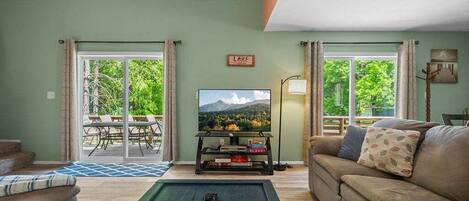 Una sala de estar con un sofá, una mesa de centro, un televisor y un cartel que dice 'LAKE'.