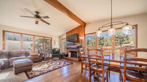 A spacious living room with a fireplace, wooden dining table, and comfortable seating. - Hot tub, great views, huge deck. Near town, RMNP (Estes Park)