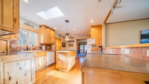 Une cuisine spacieuse avec des meubles en bois, un îlot central et une lucarne.