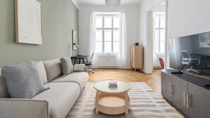 A modern living room with a sofa, a small round table, a TV, and a cabinet. - Blueground | Innere Stadt, view, nr Danube Canal (Vienna)