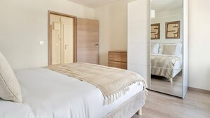 Ein Schlafzimmer mit einem Bett, einem Kleiderschrank und einem Spiegel.