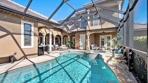 Un espace piscine doté d’un toit en verre, de chaises longues et d’une terrasse.