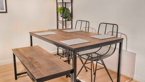 A dining table with four chairs, a bench, and a plant in the background. - GuestReady - Historic Cavern Quarter gem (Liverpool)