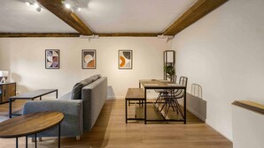 A modern living room with a sofa, a coffee table, a dining table with chairs, and artwork on the walls. - GuestReady - Historic Cavern Quarter gem (Liverpool)