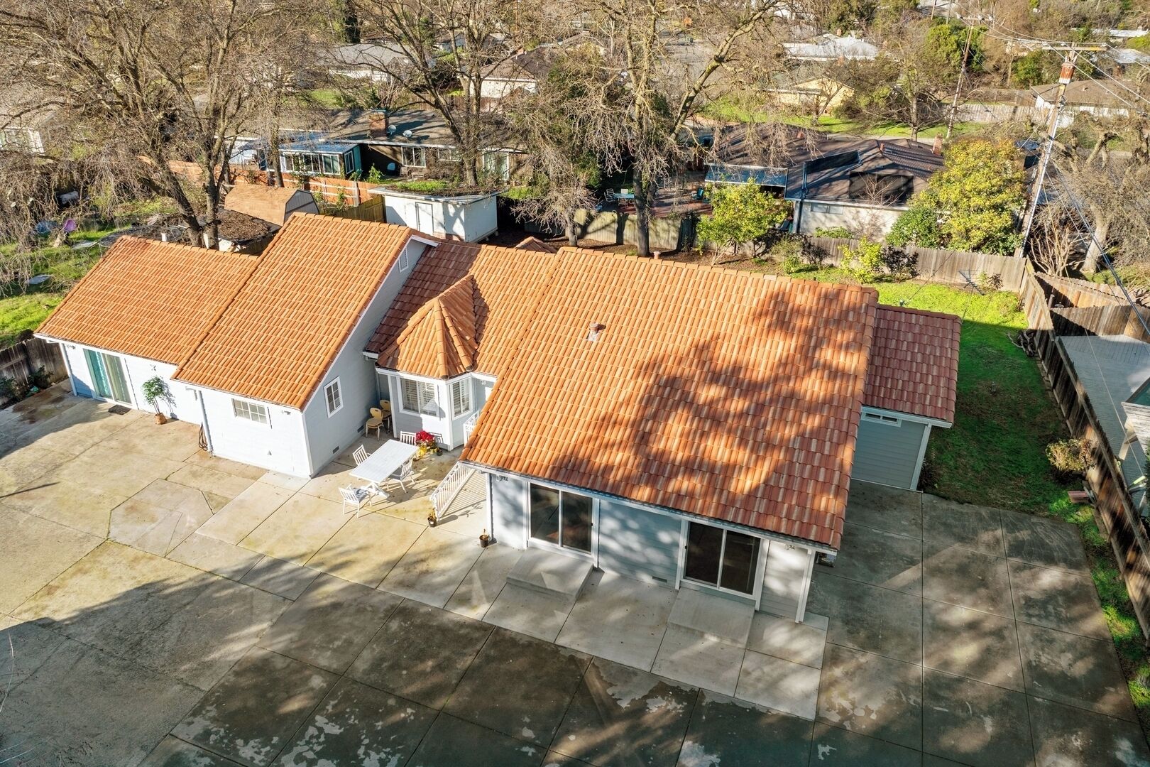 A residential area with two detached houses featuring red-tiled roofs and white exteriors.