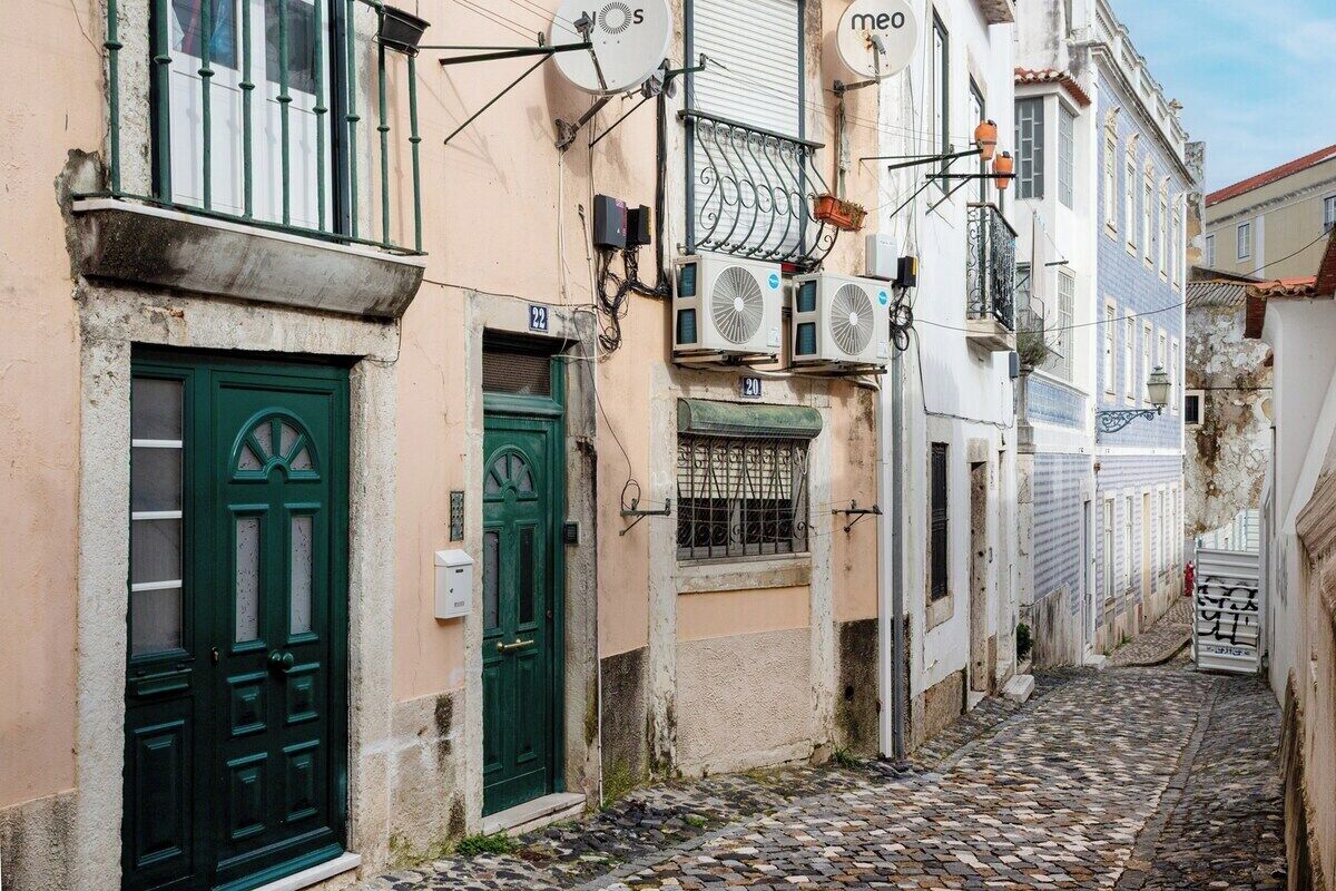 Eine schmale Straße mit Häusern an beiden Seiten, die traditionelle Architektur mit Balkonen und Türen zeigen.
