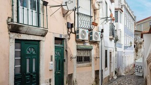 Una calle estrecha flanqueada por edificios con arquitectura tradicional, balcones y puertas.