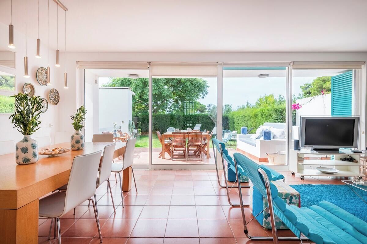 Un grand espace de vie comprenant une table à manger, des chaises, un canapé et un téléviseur.