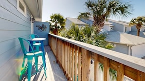 A wooden deck with a railing, a turquoise chair, and a table. - Feelin Beachy, Shared Pool, Walk to the Beach (Port Aransas)