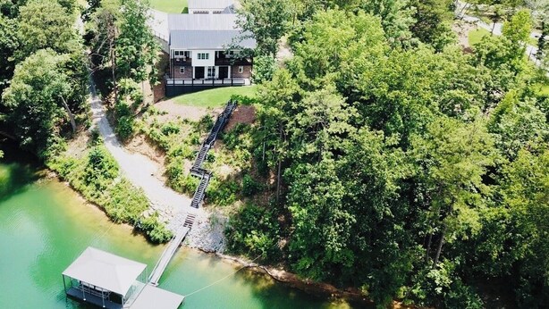 An aerial view of a lakeside property with a dock, a house, and a boat house. - 5BR Lakefront Retreat — Quiet Cove, Large Private Dock & Easy Boat Access (Bremen)