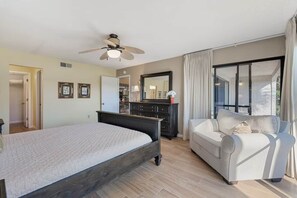 A bedroom with a bed, a dresser, a mirror, a ceiling fan, and a window with curtains. - Spacious 3BD/3BA Edgewater Beach Villa (Panama City Beach)