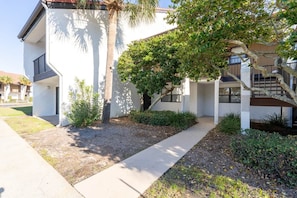 A modern building with a white exterior, a covered outdoor area, and a staircase leading to an upper level. - Spacious 3BD/3BA Edgewater Beach Villa (Panama City Beach)