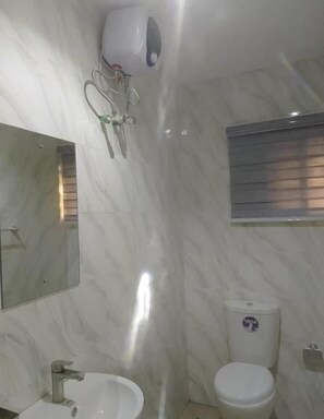 Een douche, handdoeken, toiletpapier