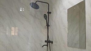 Une salle de bain avec une douche, un lavabo et un miroir au mur.