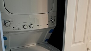 A front view of a washer and dryer unit with control knobs, a start button, and an ENERGYGUIDE sticker.