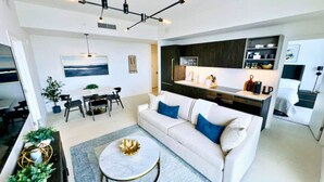 Ein modernes Wohnzimmer mit Sofa, Couchtisch und Essbereich.
