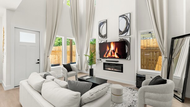 A modern living room with a fireplace, a television, and a sofa.