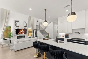 A modern kitchen with white cabinets, a central island, and a built-in stove. - Spacious 5-bedroom house in lovely Dallas near airport and downtown. (Dallas)